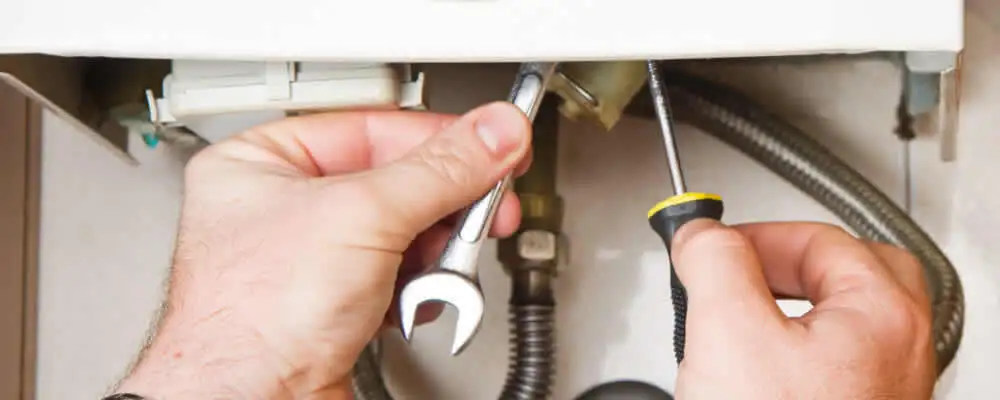 Boiler repair technician tightening pipe fittings and connections in Highland Park, IL