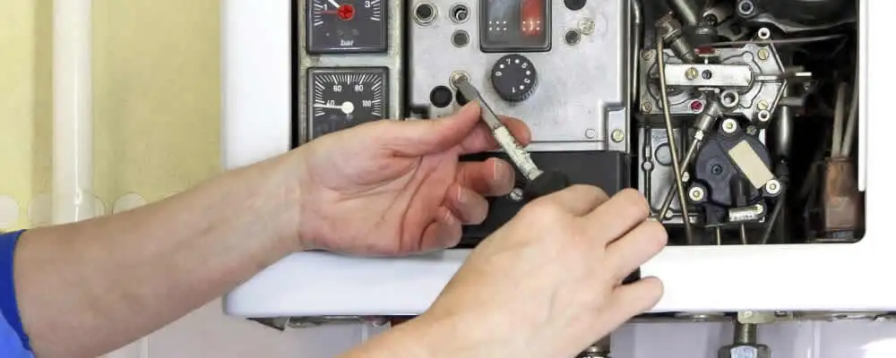 Heating repair technician adjusting boiler controls and components in Highland Park, IL