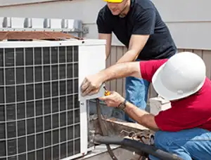 HVAC technicians repairing an outdoor AC unit on a rooftop in Highland Park, IL