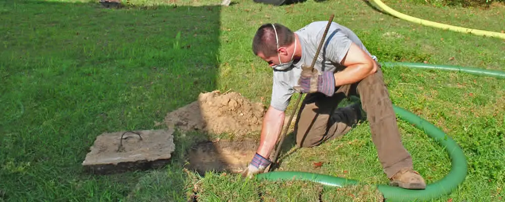 Septic pumping technician servicing a residential septic tank in Highland Park, IL