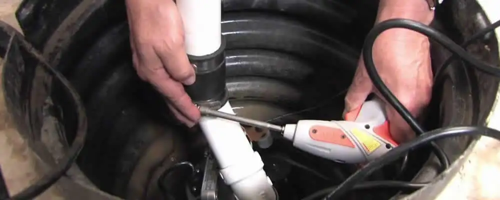 Sump pump installation technician connecting PVC discharge piping in Highland Park, IL